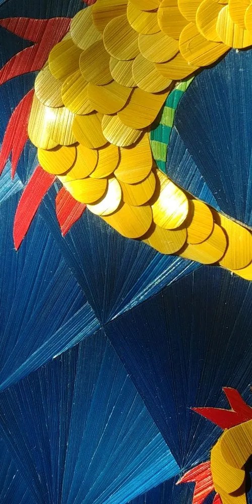 oeuvre d'art - détail sur la queue où l'on distingue les écailles qui se chevauchent et les franges de flamme