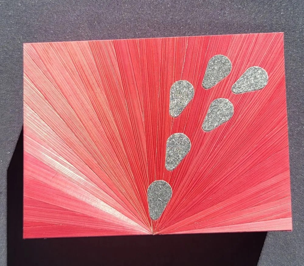 La lumière de la marqueterie de paille Détails du couvercle de la boite recouverte en marqueterie de paille rose avec des pétales de couleurs brillants argentés