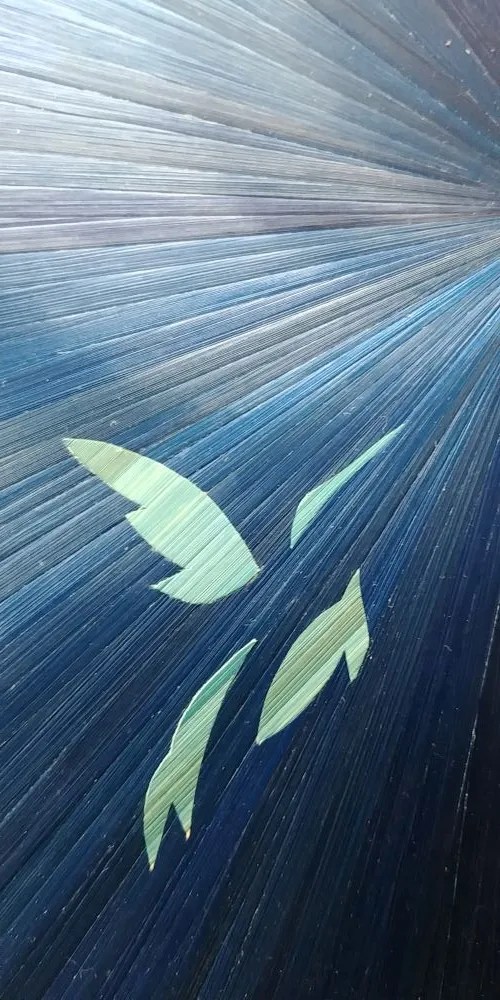 Zoom sur la décoration d'un boîte à thé ou coffret à chocolats avec un colibri bleu nuit au cœur d'un soleil bleu ciel