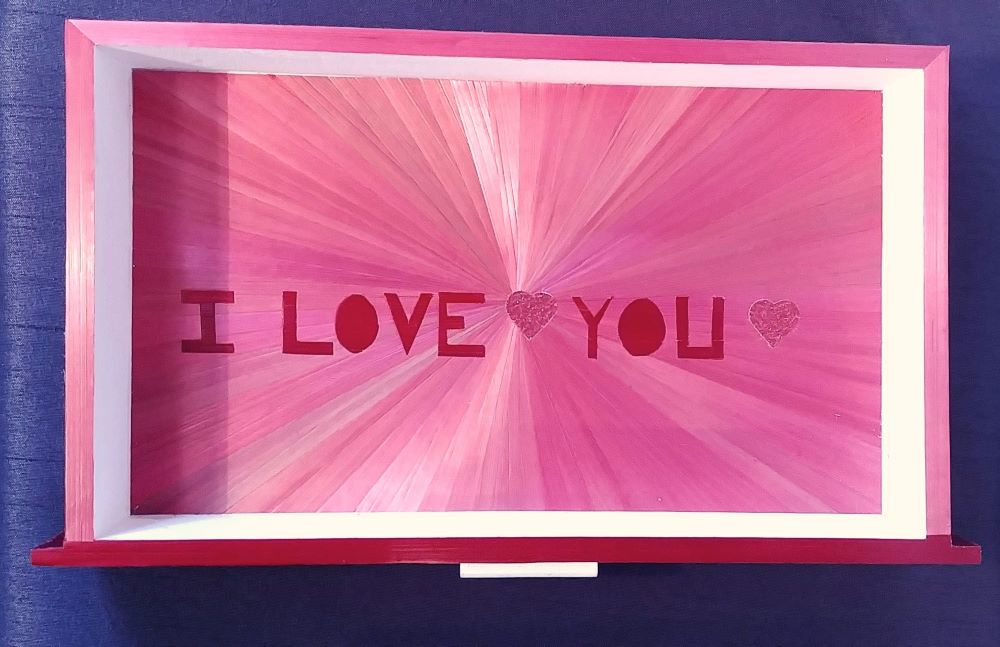 Fond du tiroir de la boîte à bijoux haut de gamme. Soleil avec des pailles de couleurs roses en motif du soleil. incrustation de la phrase "I love you"