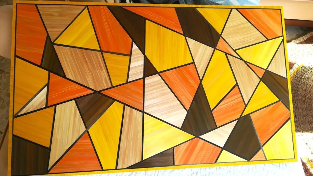 Table basse recouverte de rubans de paille couleur orange, jaune or, beige, marron