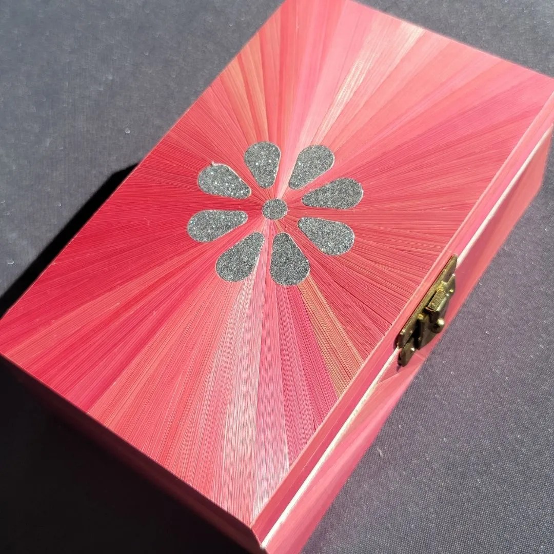 Soleil rose sur couvercle boîte avec une marguerite argentée