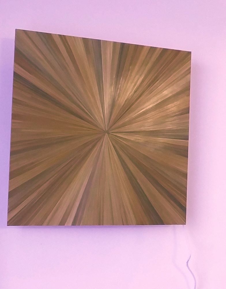 applique murale cuivre posée sur un mur en motif du soleil